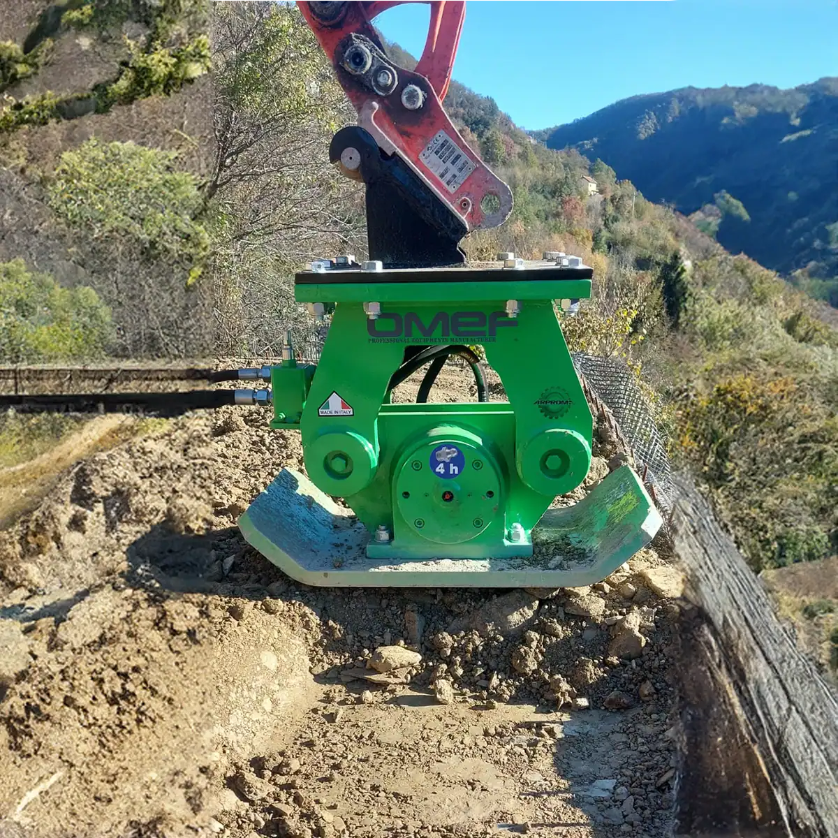 Green OMEF CPT series soil compactor on a red excavator, consolidating the fill on a benched mountain access track